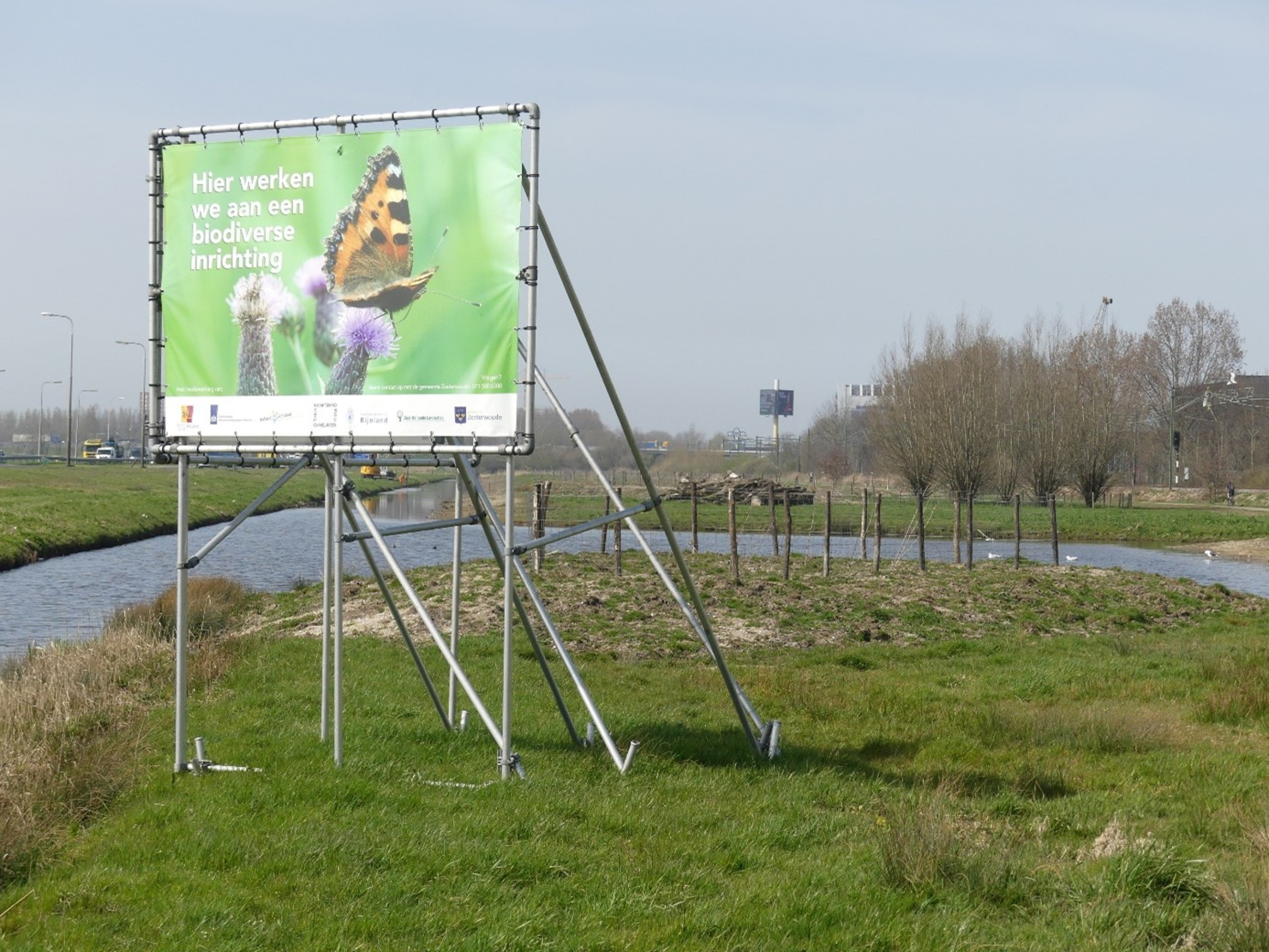 Landschap: Elfenbaan met groot bord 'hier werken we aan een biodiverse inrichting'. 
