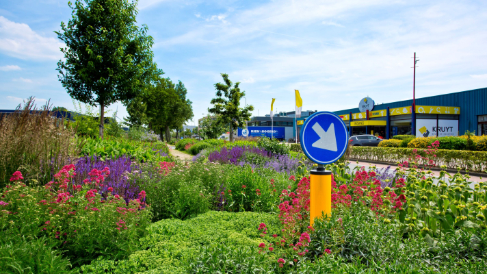 Bedrijventerrein met bloeiende planten in de middenberm